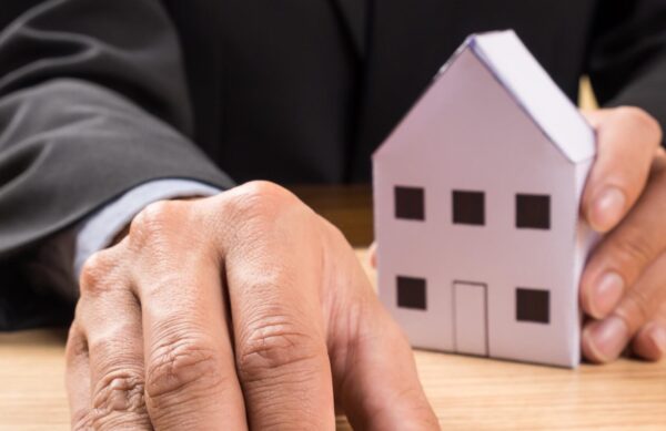 Real estate agent with house model and keys.
