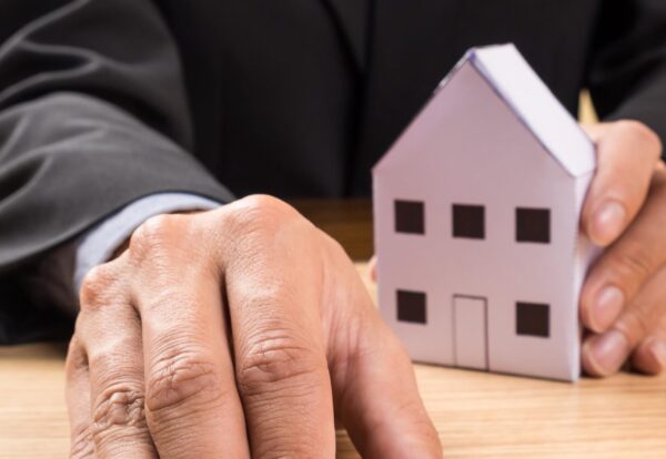 Real estate agent with house model and keys.