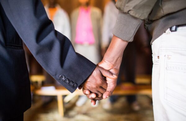 A shallow focus shot of two people holding hands with each other